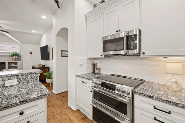 a kitchen with granite countertop a stove and a microwave