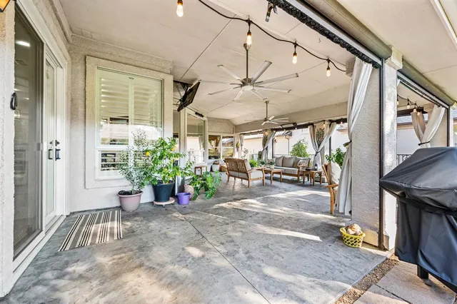 a view of a porch with chairs and potted plants