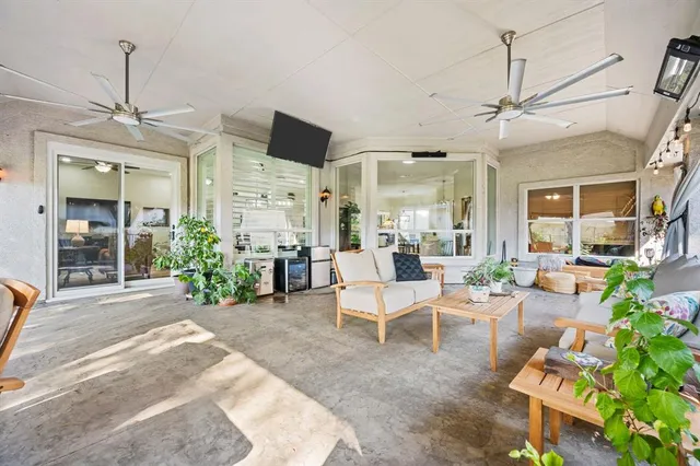 a living room with furniture a chandelier and a flat screen tv