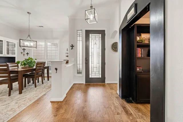 a view of a hallway with wooden floor windows a chandelier and livingroom view