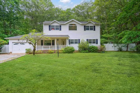 a front view of a house with a yard and trees