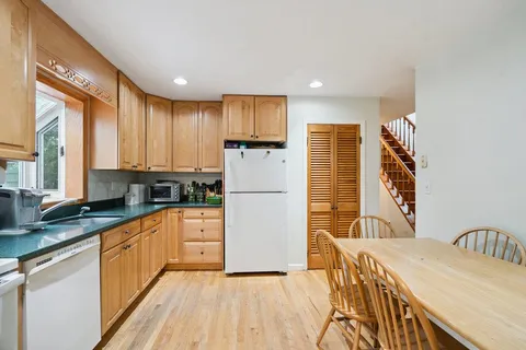 a kitchen with stainless steel appliances granite countertop a refrigerator a stove top oven a sink and dishwasher