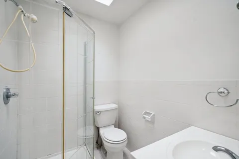 a white toilet sitting next to a bathroom sink and a shower