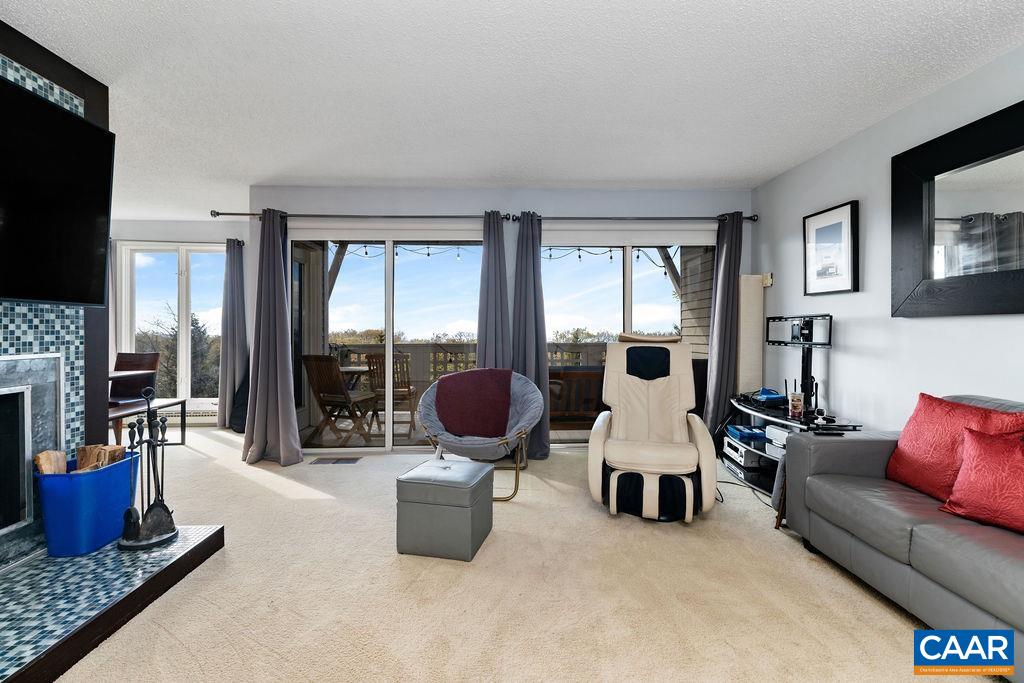 a living room with furniture a flat screen tv and a fireplace