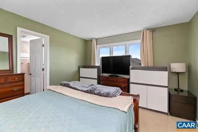 a bedroom with a bed and a flat screen tv