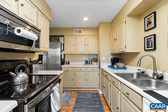 a kitchen with a sink stainless steel appliances and cabinets
