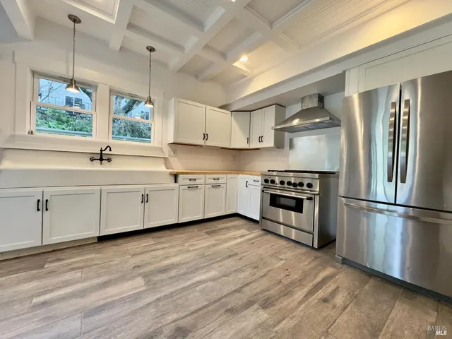 a kitchen with white cabinets stainless steel appliances and a window
