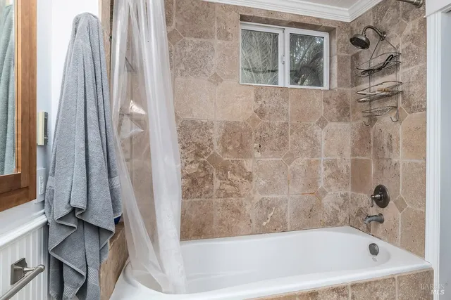 a bedroom with a bed and a flat tv screen on the dresser