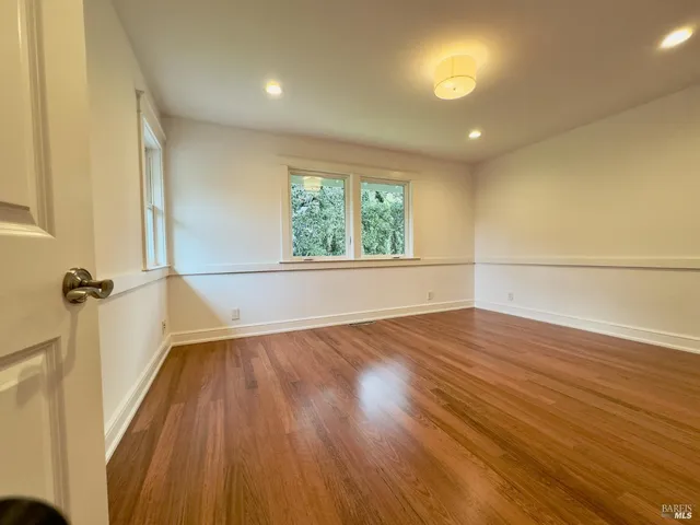 a view of a patio with couches table and chairs under an umbrella