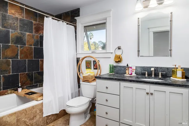 a view of backyard with seating space and wooden fence