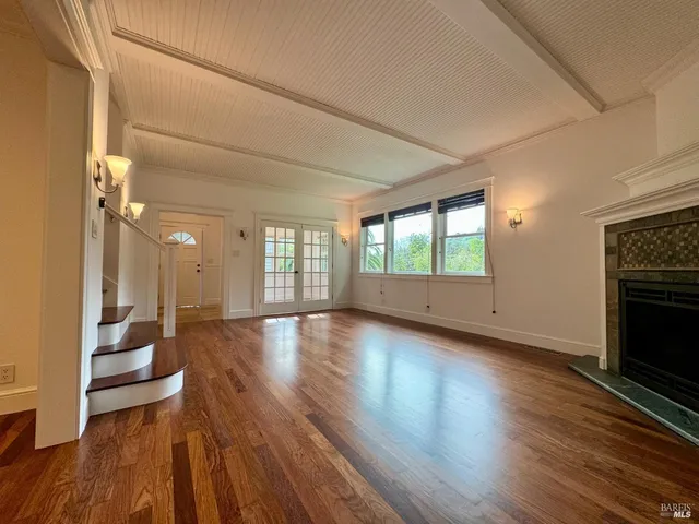 a view of a livingroom with wooden floor and a fireplace