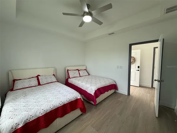 a bedroom with two beds and a chandelier