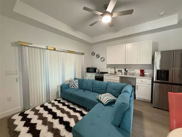 a living room with furniture and kitchen view
