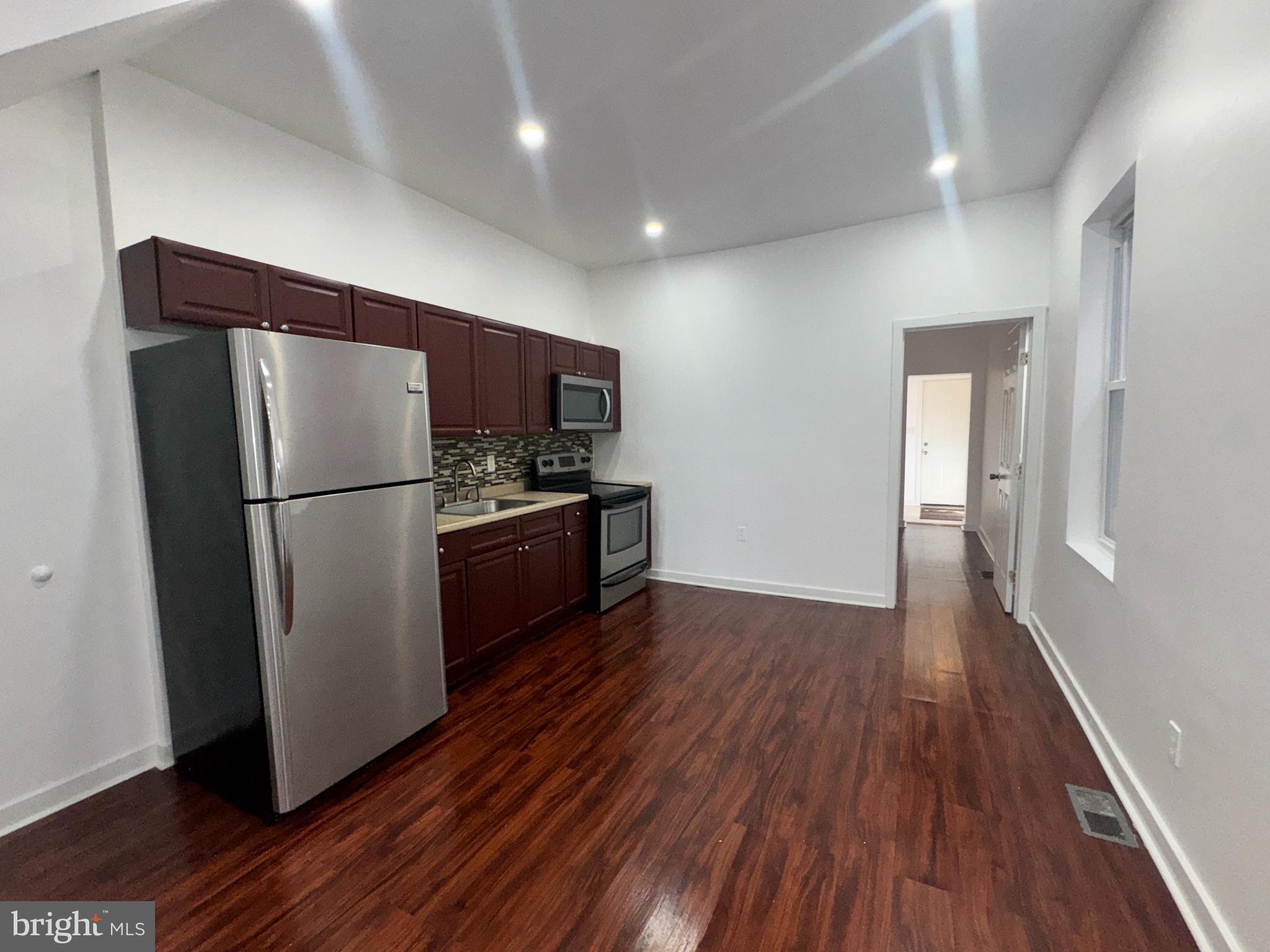 126 North Paxon Street Philadelphia, PA 19139 - Photo 12 of 38 a kitchen with a refrigerator and wooden floor