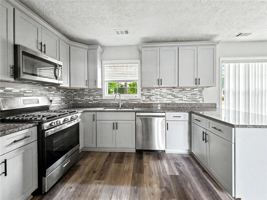 48 Savanna Court Powder Springs, GA 30127 - Photo 12 of 28 a kitchen with stainless steel appliances granite countertop a stove a sink and a microwave