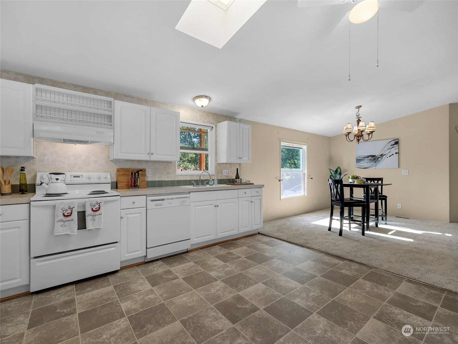 30511 Stackpole Lane Ocean Park, WA 98640 - Photo 13 of 40 a kitchen with a stove a sink cabinets and dining table chair