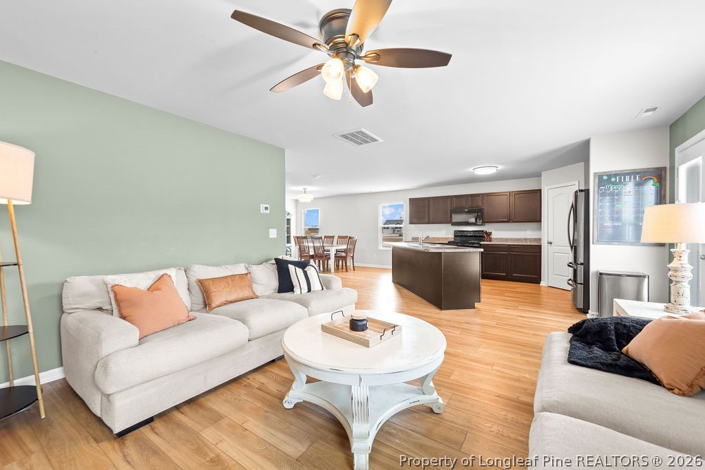 81 Merlin Court Godwin, NC 28344 - Photo 11 of 34 a living room with furniture kitchen view and a chandelier