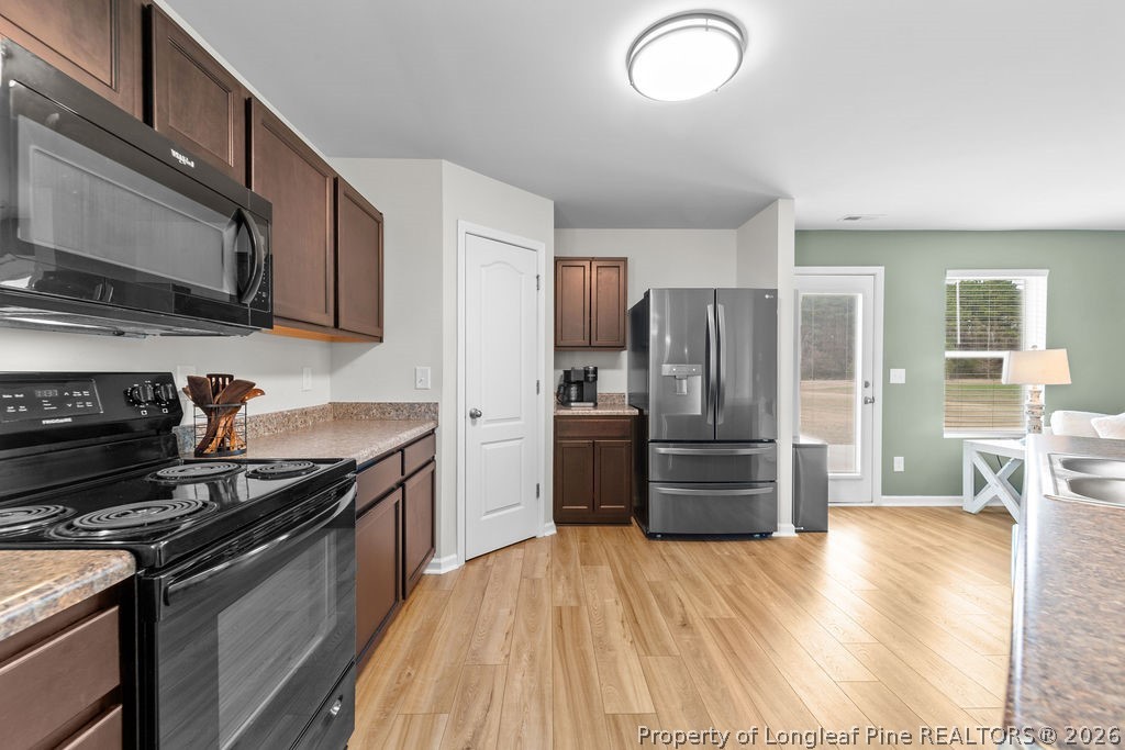 81 Merlin Court Godwin, NC 28344 - Photo 12 of 34 a kitchen with granite countertop stainless steel appliances and wooden cabinets