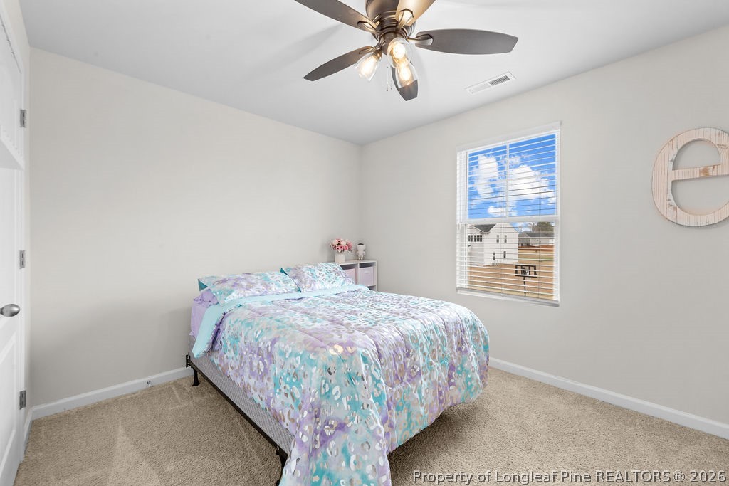 81 Merlin Court Godwin, NC 28344 - Photo 20 of 34 a bedroom with a bed and a chandelier