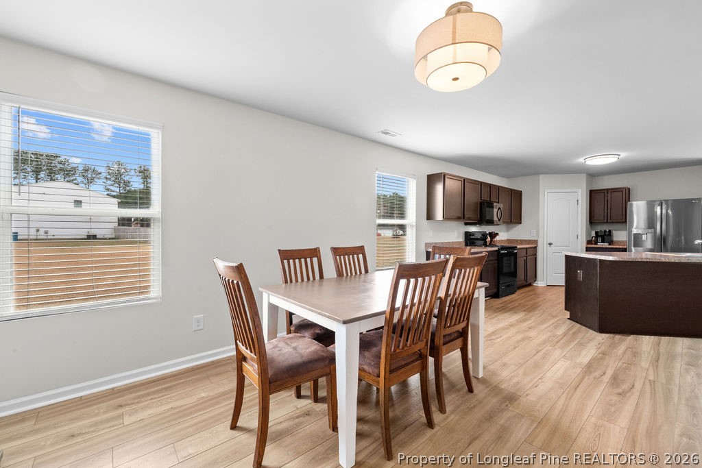 81 Merlin Court Godwin, NC 28344 - Photo 5 of 34 a view of a dining room with furniture a kitchen and chandelier