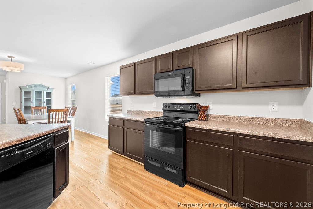81 Merlin Court Godwin, NC 28344 - Photo 7 of 34 a kitchen with granite countertop wooden cabinets and stainless steel appliances