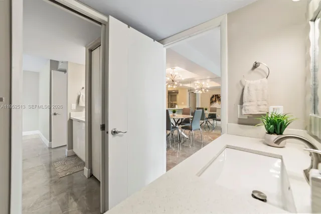 a view of a hallway with dining area and chandelier