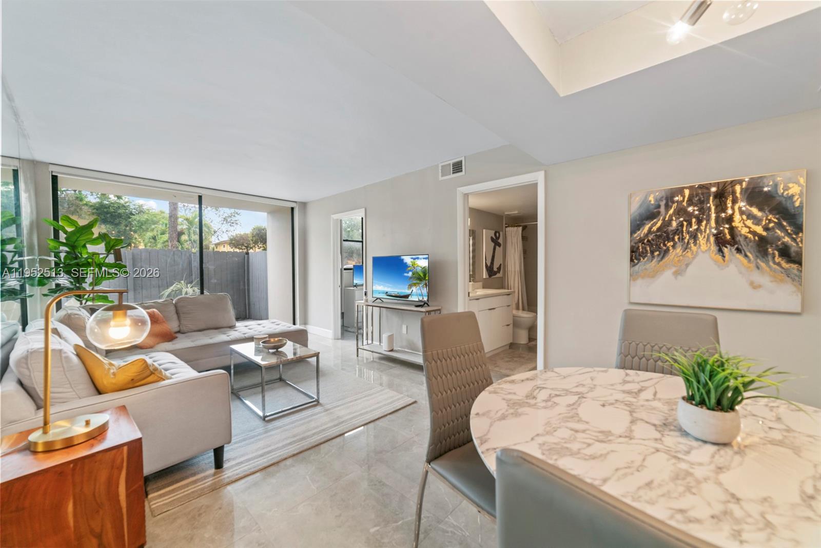 8002 Southwest 149th Avenue, Unit B118 Miami, FL 33193 - Photo 12 of 23 a living room with furniture and large windows