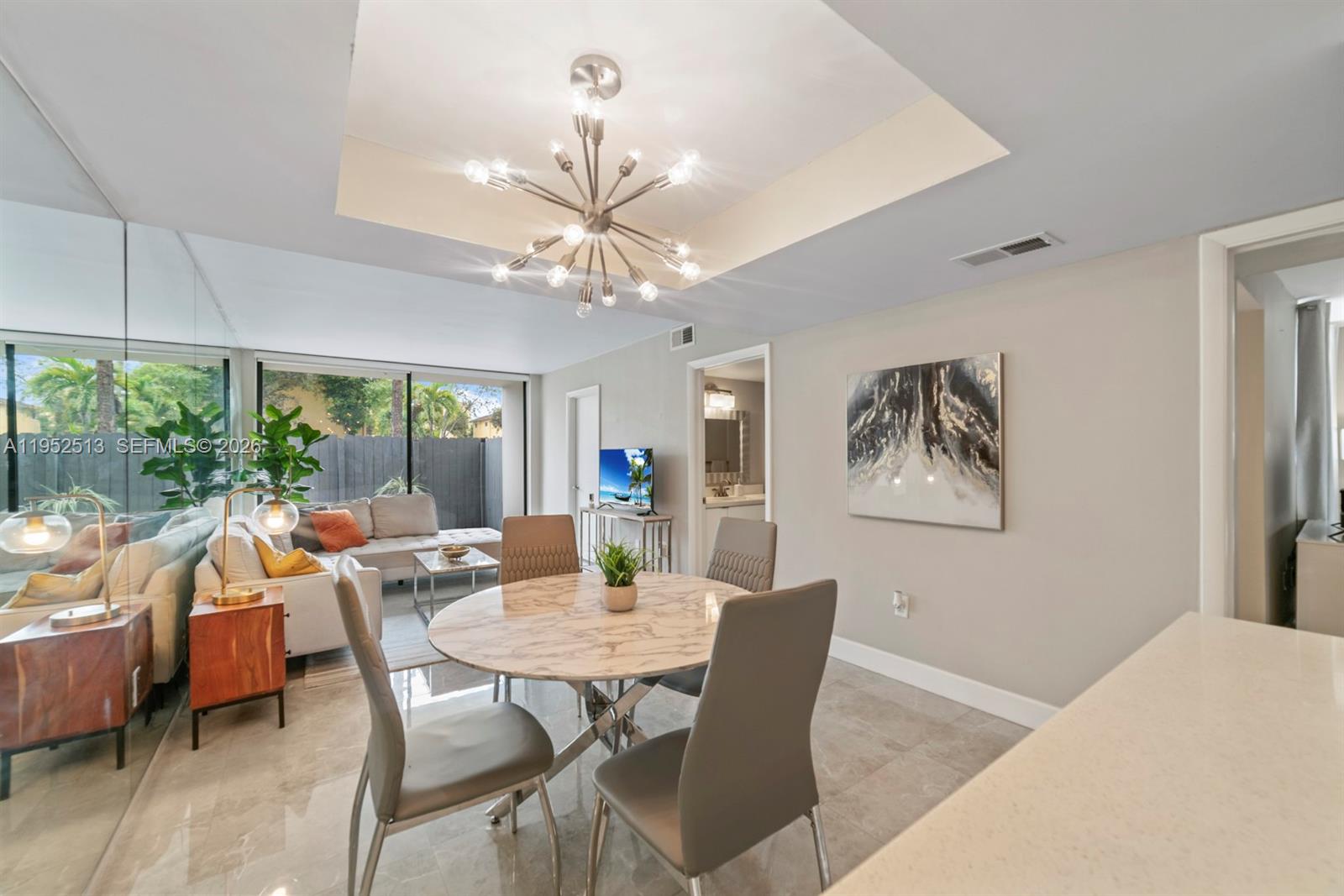8002 Southwest 149th Avenue, Unit B118 Miami, FL 33193 - Photo 13 of 23 a view of a dining room with furniture wooden floor and chandelier