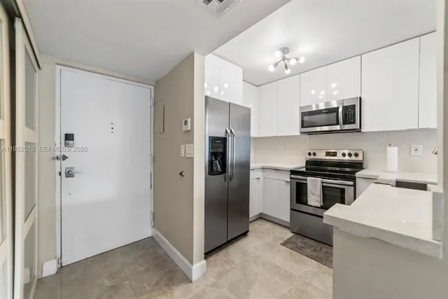 a kitchen with stainless steel appliances granite countertop a stove and a refrigerator