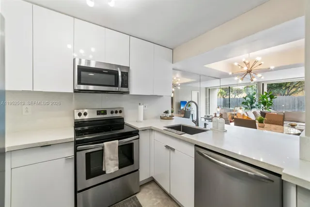 a kitchen with stainless steel appliances a stove microwave and sink