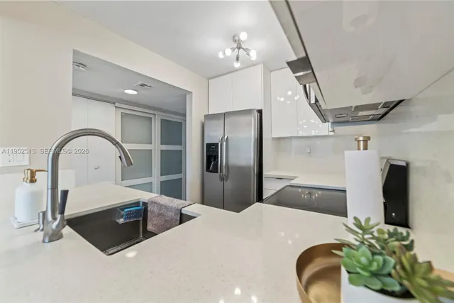 a kitchen with stainless steel appliances wooden floor dining table and a refrigerator