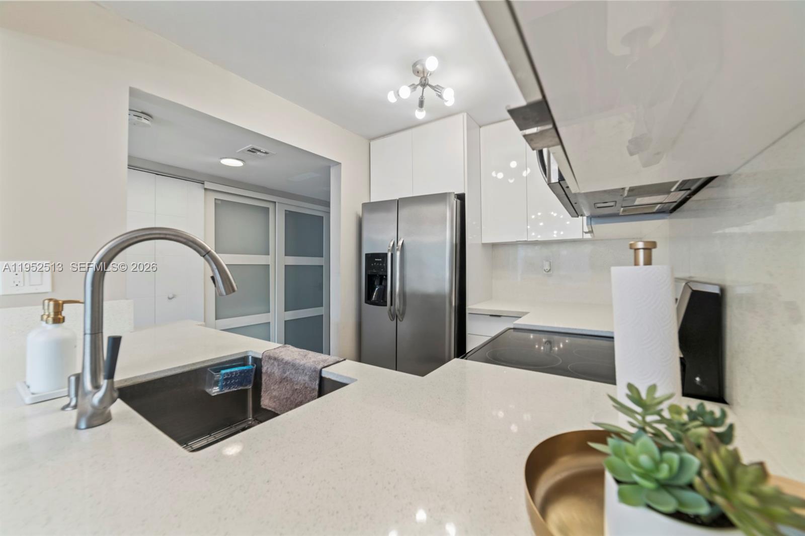 8002 Southwest 149th Avenue, Unit B118 Miami, FL 33193 - Photo 4 of 23 a kitchen with stainless steel appliances wooden floor dining table and a refrigerator