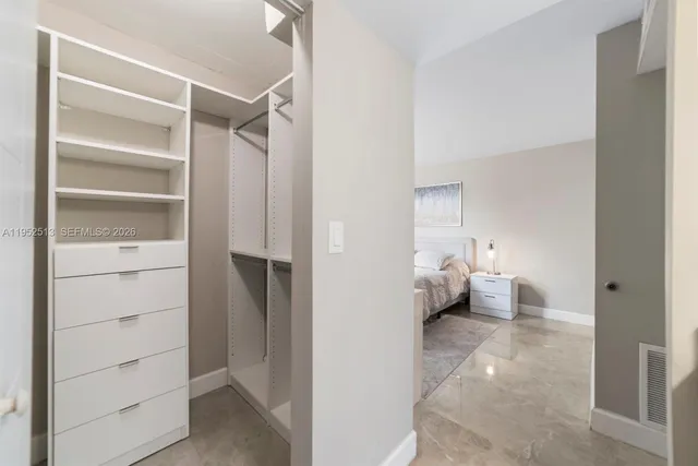 a view of walk in closet with clothes and shoes
