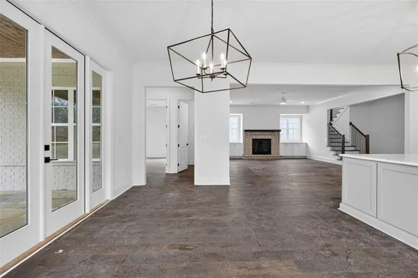 an empty room with windows and chandelier fan
