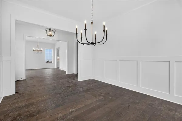 a view of a livingroom with wooden floor a ceiling fan and windows