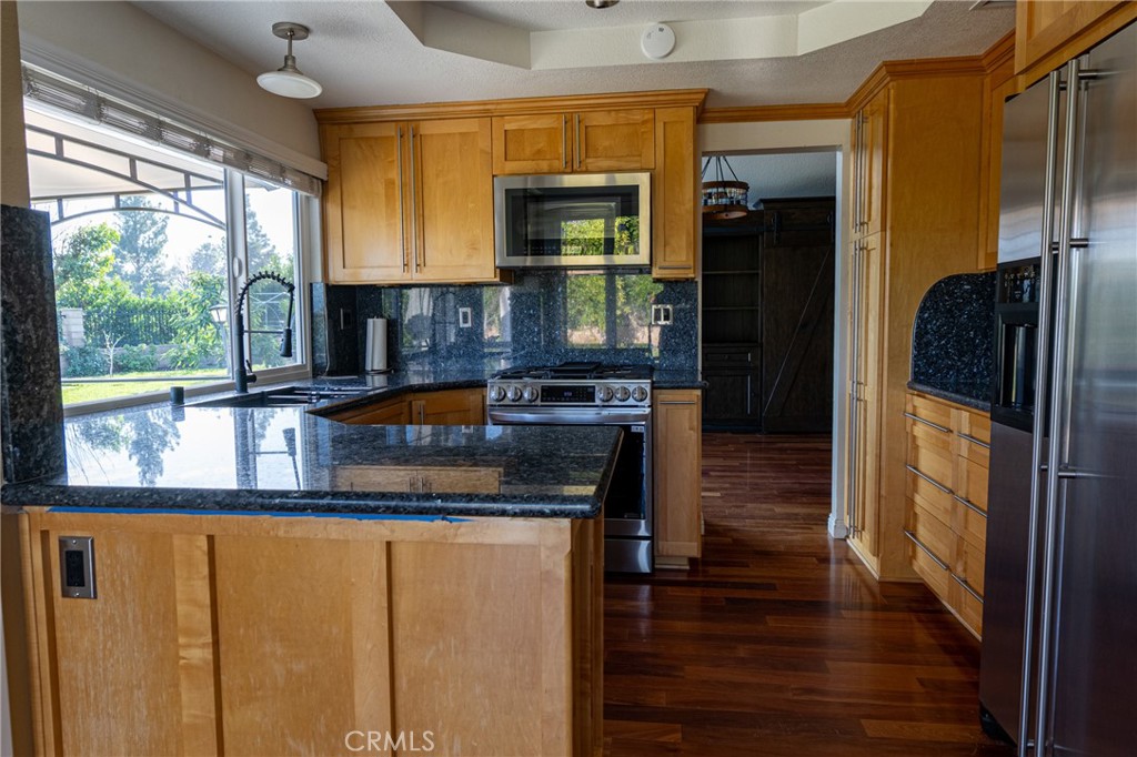 1202 Villanova Place Riverside, CA 92506 - Photo 11 of 59 a kitchen with stainless steel appliances granite countertop a refrigerator and a stove