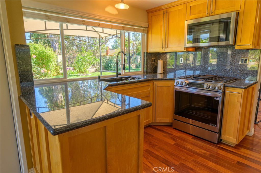 1202 Villanova Place Riverside, CA 92506 - Photo 7 of 59 a kitchen with stainless steel appliances granite countertop a stove a sink and a microwave