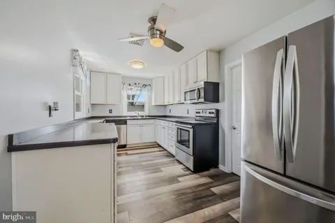 a kitchen with stainless steel appliances granite countertop a refrigerator a stove a sink and a microwave