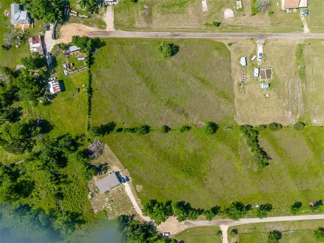 an aerial view of a residential houses with yard
