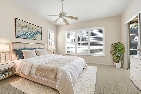 a bedroom with a large bed and a potted plant