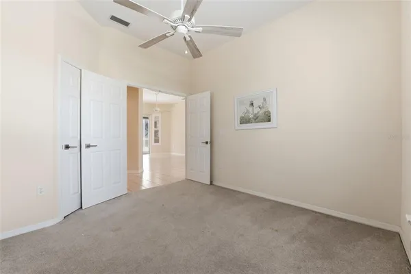 an empty room with windows and fan