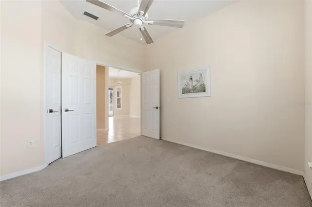 an empty room with windows and fan