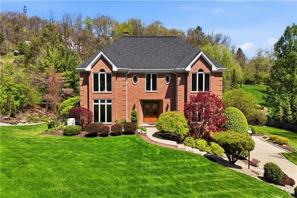 a front view of a house with a yard and trees