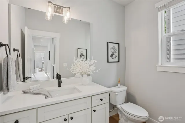 a bathroom with a sink a toilet and a mirror