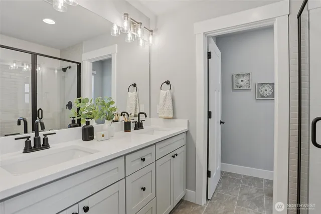a bathroom with double vanity sink a mirror and a shower