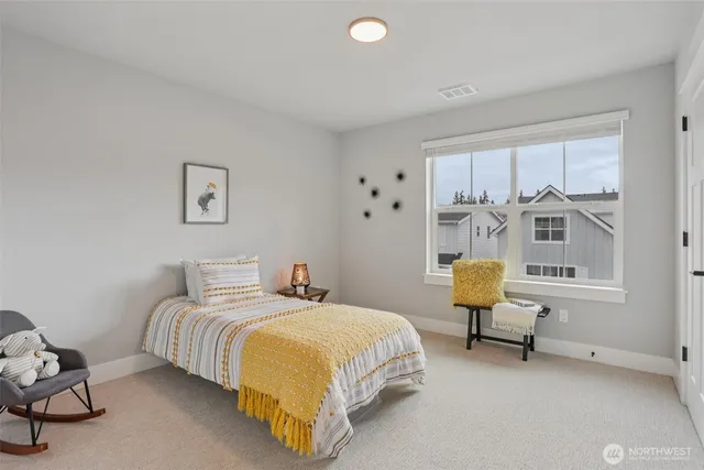 a bedroom with a bed chair and a window