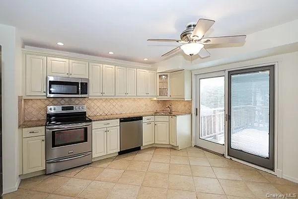 a kitchen with granite countertop stainless steel appliances a stove top oven and sink
