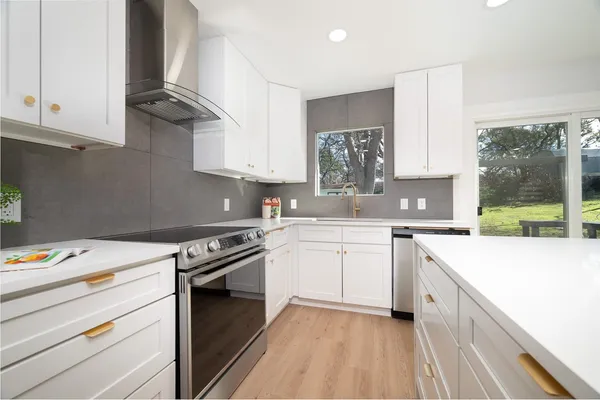 a kitchen with a sink stove and white cabinets