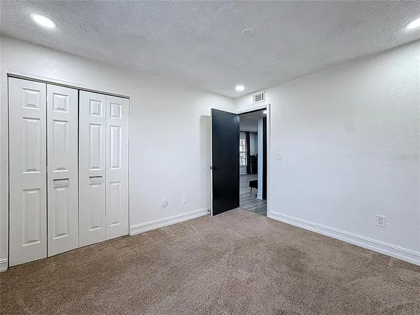 an empty room with windows and closet