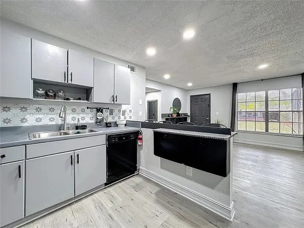 a kitchen with refrigerator and chairs